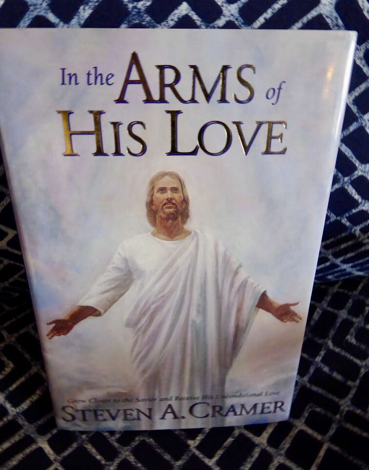 IN THE ARMS OF HIS LOVE- By Steven A. Cramer- Nice Looking Hardback Book With A Dust Jacket