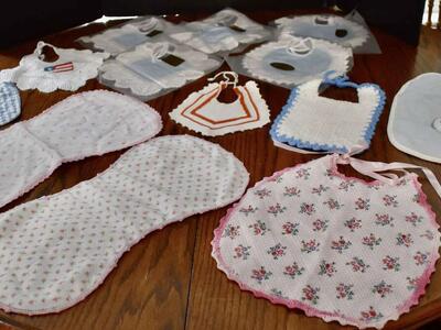 SEVERAL VINTAGE AND SOME NEW BABY BIBS AND A COUPLE OF NEW BURP CLOTHS
