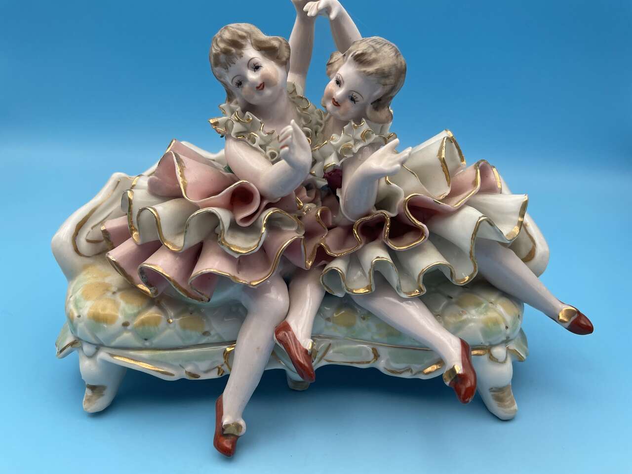 Two Well Dressed Girls Sitting on a Sofa Singing