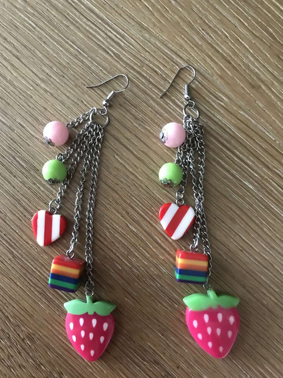 Earrings with a strawberry, a rainbow box and a heart on them