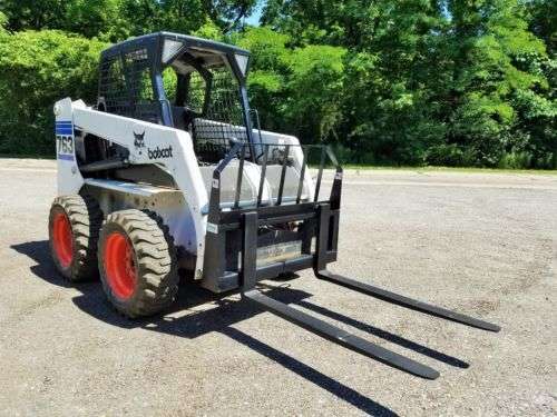 Skid steer with grapple bucket, pallet forks, concrete breaker, rock bucket, auger