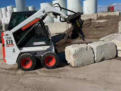 Mini 36 inch Bobcat for rent with concrete breaker jackhammer attachment. Also forks, auger, trencher, and more!