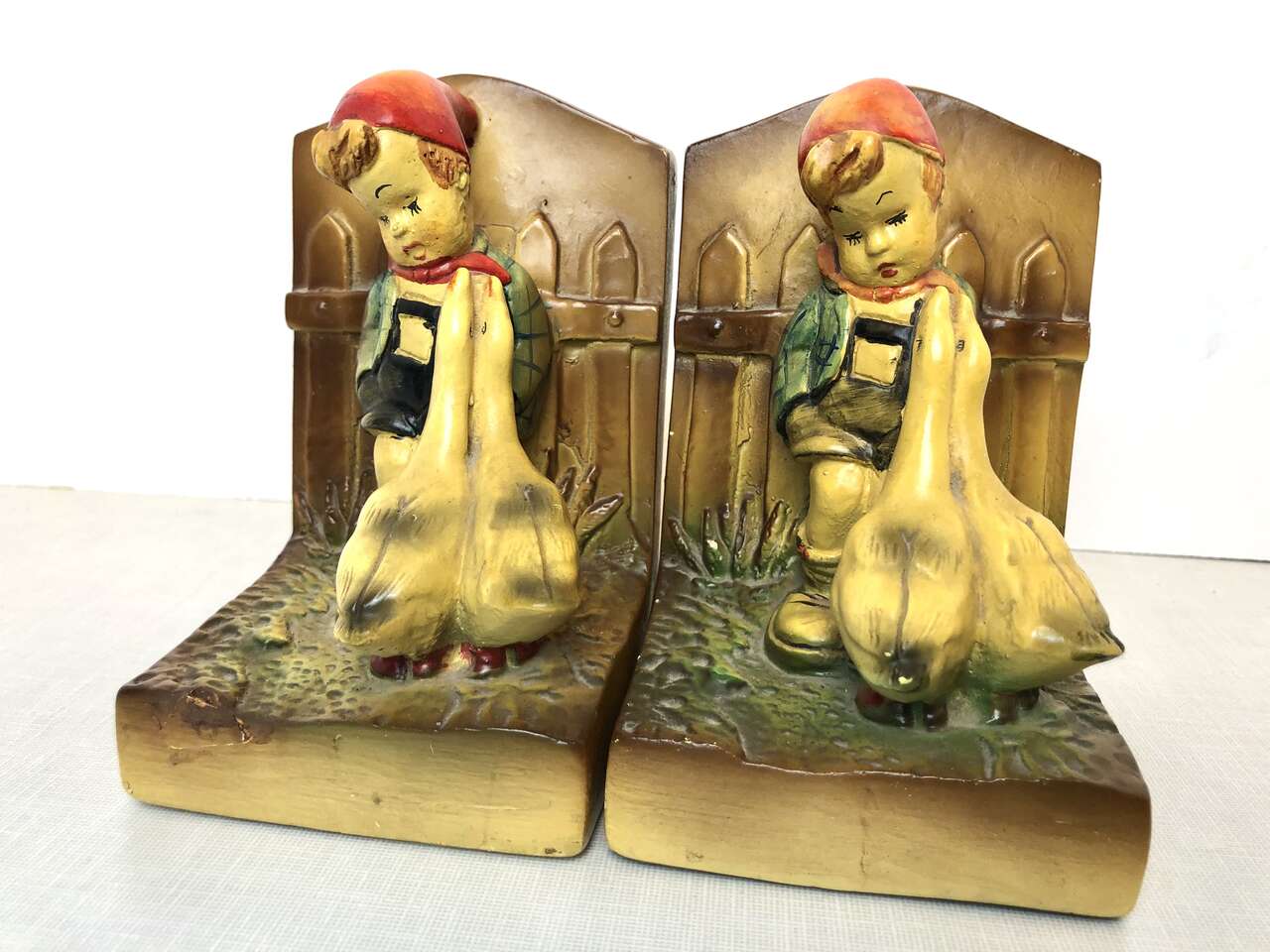Matching pair of antique Hummel-goebel style chalkware bookends. Boy with dog and girl w geese vintage