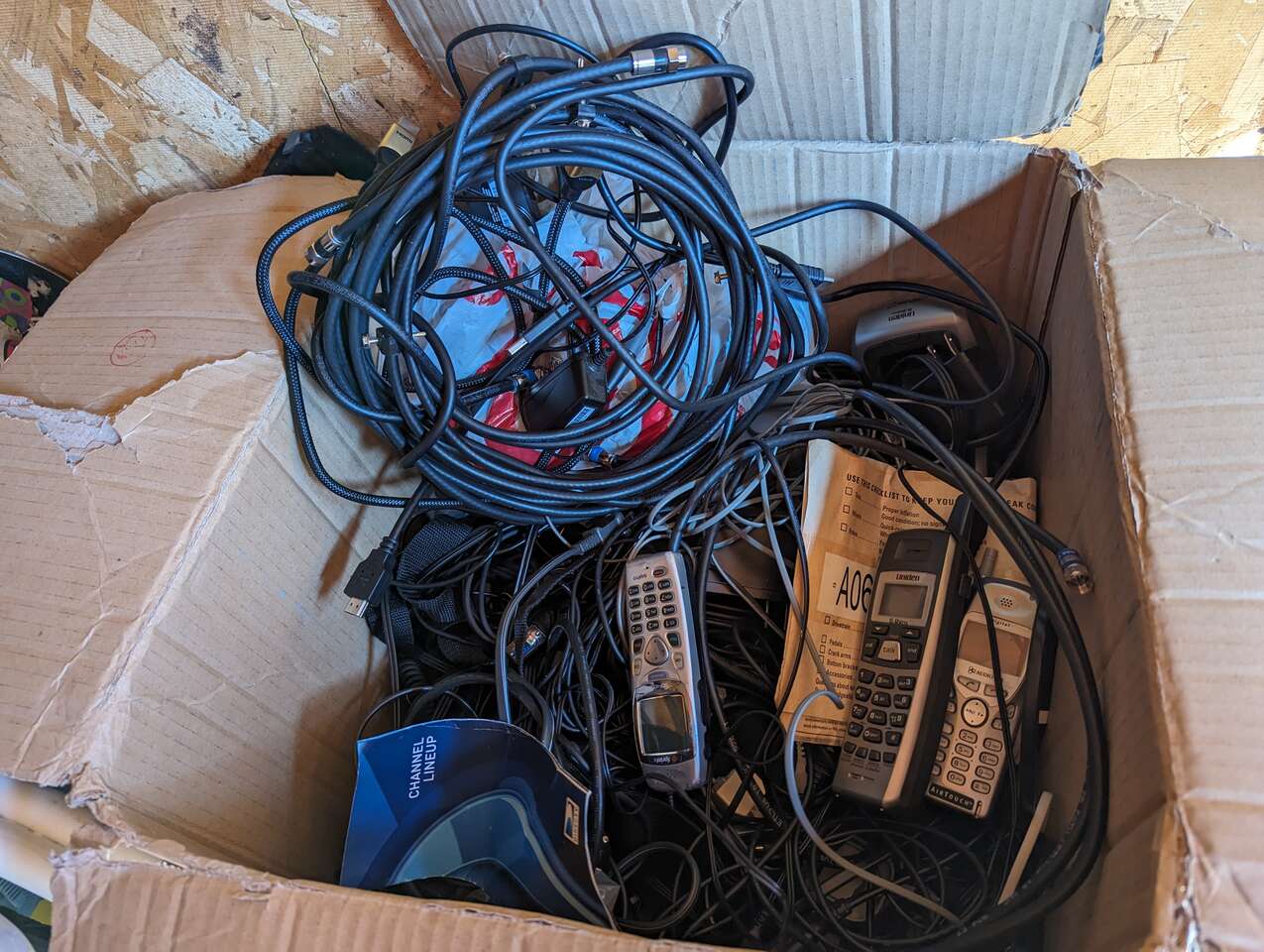 Box of cords and old phones