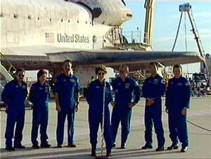 In this image from NASA television, Commander Eileen Collins, center, thanks everyone for a safe flight with the space shuttle Discovery in the background at Edwards Air Force Base in Calif. Tuesday, Aug. 9, 2005. The crew from left to right are astronaut Charles Camarda, astronaut Wendy Lawrence, astronaut Steve Robinson, Collins, astronaut Andy Thomas, Japanese astronaut Soichi Noguchi, and pilot James Kelly. (AP Photo/NASA TV)