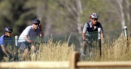 President Bush leads a group of bicyclists on mountain bikes along a path near Lake Cascade State Park in Donnelly, Idaho, Tuesday, Aug. 22, 2005. President Bush arrived Monday afternoon by helicopter in Donnelly, where he's due to spend two nights at the ski and golf resort that opened in December 2004. (AP Photo/Elaine Thompson)