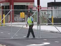 A guard walks away aftter locking a gate to Fort McPherson in Atlanta early Wednesday, Aug. 24. 2005. An independent commission voted Wednesday to support the Pentagon's recommended closure of Fort McPherson and Fort Gillem, a move that means Atlanta's seventh-largest employer and its satellite base almost certainly will be shuttered.