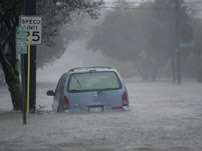 Floodwaters surround a car in uptown New Orleans early Monday, Aug. 29, 2005 as high winds and rain batter the Louisiana coast as Hurricane Katrina makes landfall.