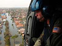In this photo released by the U.S. Coast Guard, Petty Officer 2nd Class Shawn Beaty, 29, of Long Island, N.Y., looks for survivors in the wake of Hurricane Katrina from the door of a rescue helicopter over New Orleans. Tuesday, Aug. 30, 2005. Beaty is a member of an HH-60 Jayhawk helicopter rescue crew sent from Clearwater, Fla., to assist in search and rescue efforts.
