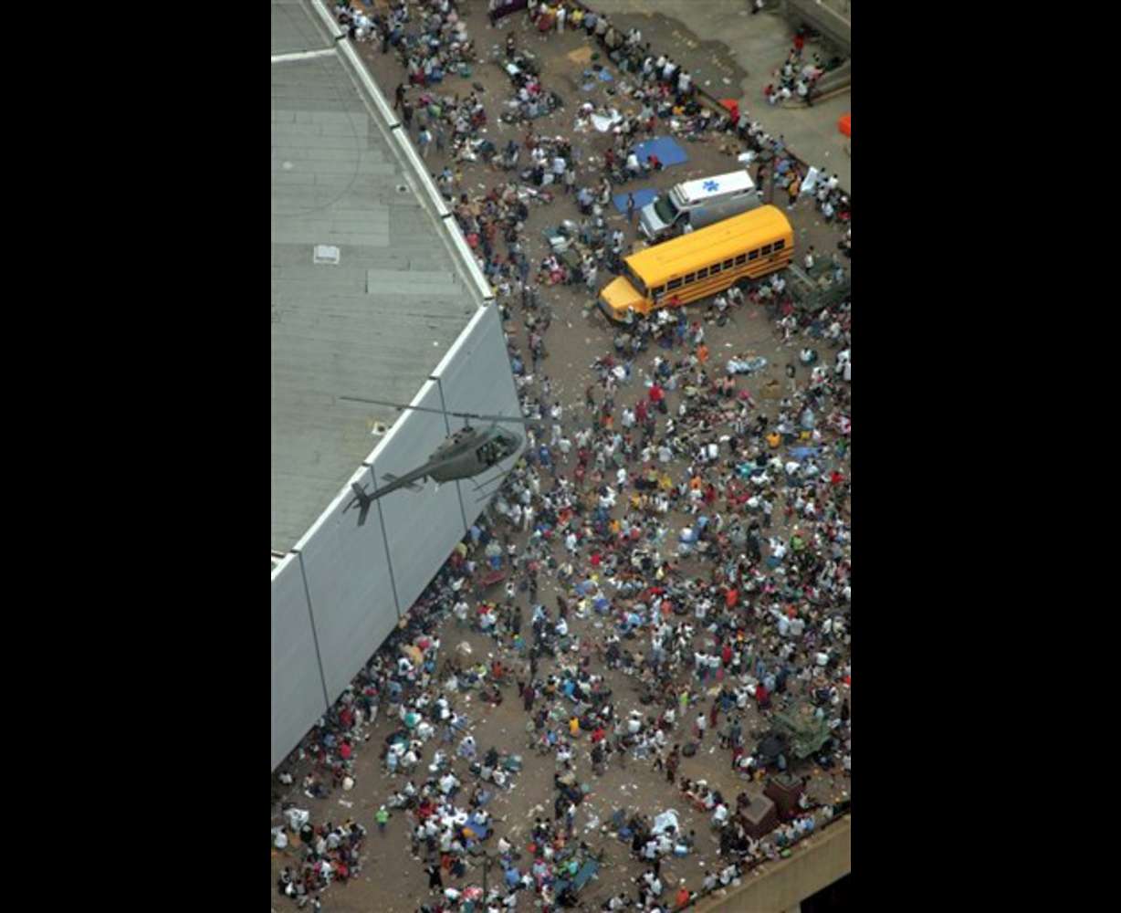 A helicopter flies over residents waiting to be evacuated from the Louisiana Superdome Thursday, Sept. 1, 2005 in New Orleans. (AP Photo/David J. Phillip,Pool)