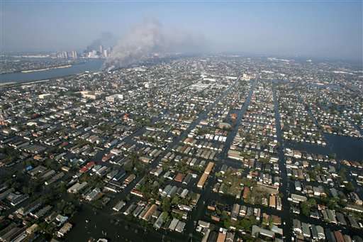 Floodwaters fill the streets as fires burn in the background Friday, Sept. 2, 2005, in New Orleans. (AP Photo/David J. Phillip, pool)