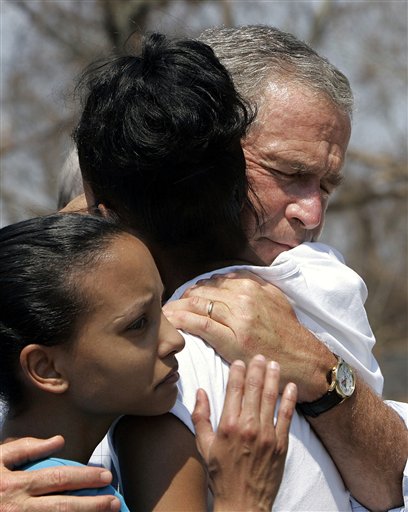President Bush tries to comfort Bronwynn Bassier, 23, of Biloxi, Miss., center, and her sister Kim Bassier, 21, left, during a walking tour of the Biloxi, Miss., that was devastated by Hurricane Katrina, Friday, Sept. 2, 2005. Bush toured the Gulf Coast communities battered by Hurricane Katrina, hoping to boost the spirits of increasingly desperate storm victims and exhausted rescuers. (AP Photo/Susan Walsh)