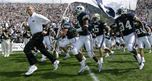 BYU' Bronco Mendenhall, left, leads his team onto the field for the first time as head coach against Boston College before the game Saturday, Sept. 3, 2005, in Provo, Utah. (AP Photo/Douglas C. Pizac)