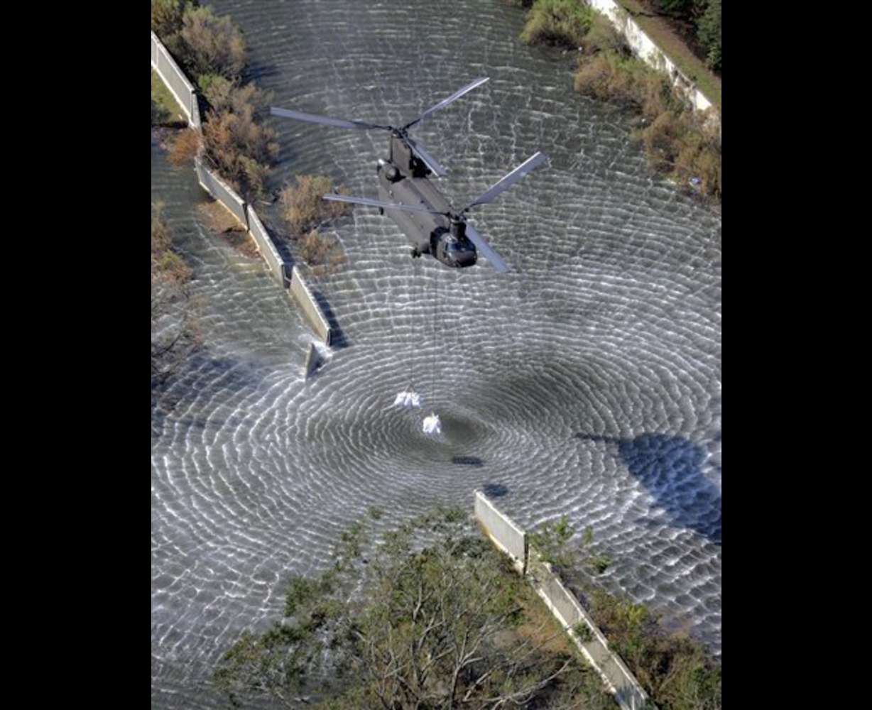 A military helicopter drops sandbags to repair a broken levee, Tuesday, Sept. 6, 2005, in New Orleans. (AP Photo/David J. Phillip, pool)