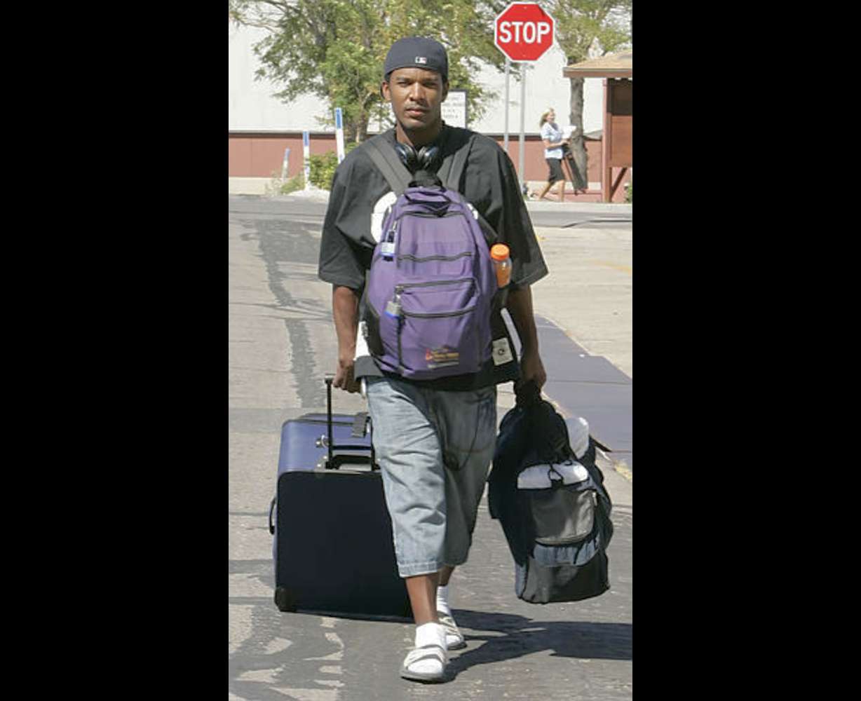 Katrina evacuee Eugene Franklin from New Orleans, carries his personal possessions in a suitcase and two backpacks as he leaves the National Guard's Camp Williams in Bluffdale, Utah, for Los Angeles to be with family Wednesday, Sept. 7, 2005. Hundreds of hurricane survivors from New Orleans are being housed at Camp Williams. (AP Photo/George Frey)