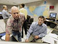 Meteorologists Jim Gross, left, and Daniel Brown, right, follow the path of Tropical Storm Rita at the National Hurricane Center Monday Sept. 19, 2005 in Miami. Officials ordered residents evacuated from the lower Florida Keys on Monday as Tropical Storm Rita churned toward the island chain, bringing with it a potential 8-foot storm surge. Hurricane warnings were posted.