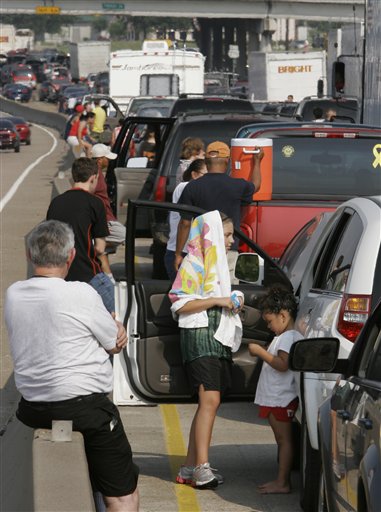 Storm evacuees stand on the side of Highway 290 which has become a parking lot as people attempt to flee Hurricane Rita in Houston on Thursday, Sept. 22, 2005. (AP Photo/Ron Heflin)