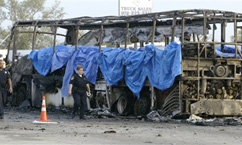 Emergency crews investigate the scene where a bus caught fire and exploded on northbound Interstate 45, Friday, Sept. 23, in Wilmer, Texas. The bus carrying elderly evacuees from Hurricane Rita caught fire and was rocked by explosions early Friday on a gridlocked highway near Dallas, killing as many as 24 people, authorities said. The bus, with about 45 people on board, had been traveling since Thursday. (AP Photo/Matt Slocum)