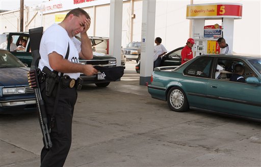 Montgomery County Deputy Tony Madison wipes sweat from his head as he patrols an open gas station in Houston on Friday, Sept. 23, 2005. Armed law officers were allowing cars to enter the station one-by-one and allowing them to purchase up to 15 gallons of gas. Fuel is in short supply as many people still are scrambling to fill their tanks before the arrival of Hurricane Rita. (AP Photo/Pat Sullivan)