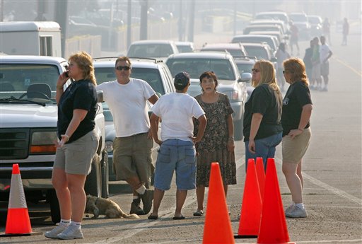 Residents stand amidst dense smoke as they wait to return to their neighborhoods following wildfires in the Bell Canyon and Woolsey Canyon areas, Friday, Sept. 30, 2005, in Los Angeles. (AP Photo/Mark J. Terrill)