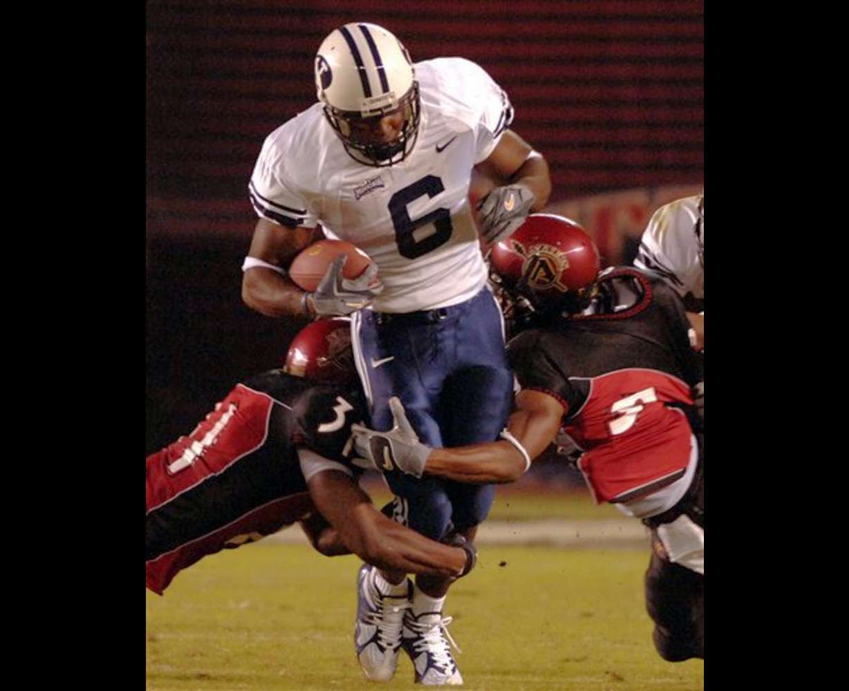 Brigham Young running back Curtis Brown (6) tries to break the tackles San Diego State's Reggie Grigsby, left, and Terrell Maze on an 8-yard run during the second quarter Saturday, Oct. 1, 2005, in San Diego. (AP Photo/Denis Poroy)