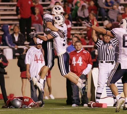 Brigham Young's Matt Allen, left, and Nathan Meikle celebrate Allen's fourth-quarter, go-ahead touchdown as New Mexico's DeAndre Wright lies on the field in dejection after he couldn't stop Allen from scoring the touchdown in Albuquerque, N.M., Saturday, Oct. 8, 2005. BYU won 27-24. (AP Photo/Jake Schoellkopf)