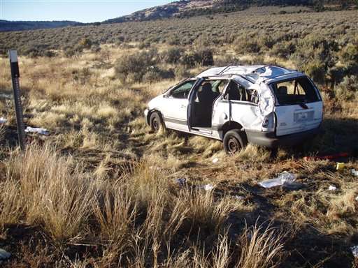 In this photo provided by the Utah Highway Patrol, a van is shown, near Moab Utah, Tuesday, Oct. 11, 2005. The van carrying as many 16 people from Phoenix to Denver rolled over on a state highway in southern Utah on Tuesday, killing a 20-year-old woman and sending 14 others to area hospitals, the Utah Highway Patrol said. (AP Photo/Utah State Police)