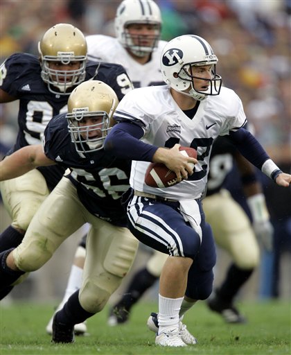 Brigham Young quarterback John Beck, right, is pressured by Notre Dame defenders Derek Landri, left front, and Trevor Laws during the second quarter in South Bend, Ind., Saturday, Oct. 22, 2005. (AP Photo/Michael Conroy)