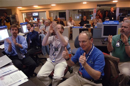 As the Stardust capsule lands under parachute at Dugway Proving Grounds in Utah, scientists and engineers in Mission Control at NASA's Jet Propulsion Laboratory react to the succesful return of the capsule Sunday, Jan. 15, 2006 in Pasadena, Calif. (AP Photo/Phil McCarten)