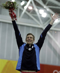 United States' Joey Cheek celebrates his gold medal victory during a flower ceremony.