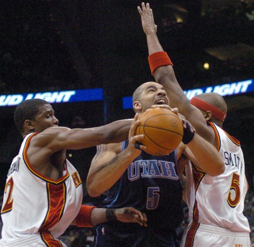 Utah Jazz forward Carlos Boozer (5) looks to shoot between Atlanta Hawks guard Joe Johnson (2) and forward Josh Smith (5) during the fourth quarter of an NBA basketball game Friday, March 17, 2006, in Atlanta. Utah won 111-101. (AP Photo/Gregory Smith)