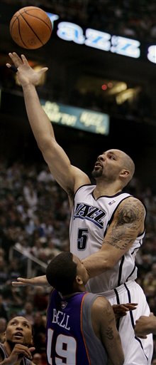 Utah Jazz forward Carlos Boozer (5) is fouled by Phoenix Suns guard Raja Bell (19) during the fourth quarter of an NBA basketball game Tuesday, March 21, 2006, in Salt Lake City. The Jazz beat the Suns, 107-99. (AP Photo/Douglas C. Pizac)