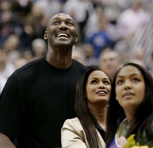 Former Utah Jazz forward Karl Malone, left, his wife Kay and their daughter Sheryl, right, smile as they look at his retired basketball jersey hanging in the rafters Thursday, March 23, 2006, in Salt Lake City. (AP Photo/Douglas C. Pizac)