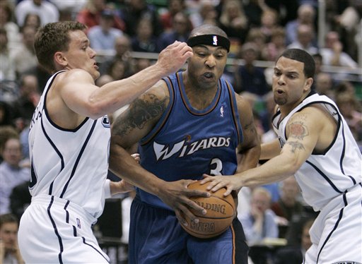 Washington Wizards forward Caron Butler (3) forces his way between Utah Jazz forward Matt Harpring and guard Deron Williams (8) during the first quarter of an NBA basketball game, Thursday, March 23, 2006, in Salt Lake City. (AP Photo/Douglas C. Pizac)