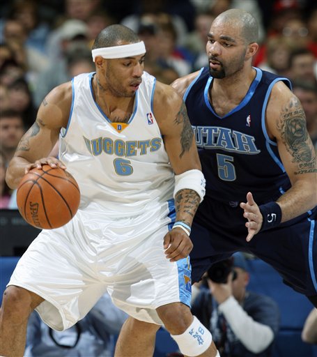 Denver Nuggets forward Kenyon Martin, left, works the ball inside for a shot against Utah Jazz forward Carlos Boozer in the first quarter of an NBA basketball game in Denver on Wednesday, March 29, 2006. (AP Photo/David Zalubowski)