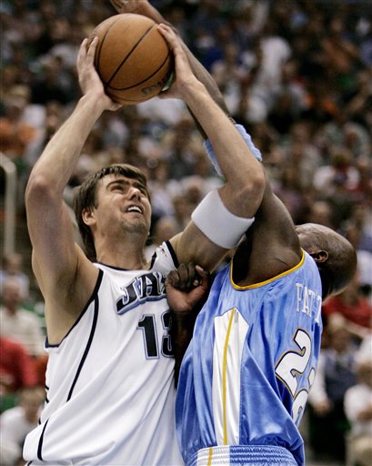 Utah Jazz forward Mehmet Okur (13), of Turkey, is fouled by Denver Nuggets forward Ruben Patterson (22) during the fourth quarter of an NBA basketball game Wednesday, April 12, 2006, in Salt Lake City. The Jazz won 104-83. (AP Photo/Douglas C. Pizac)