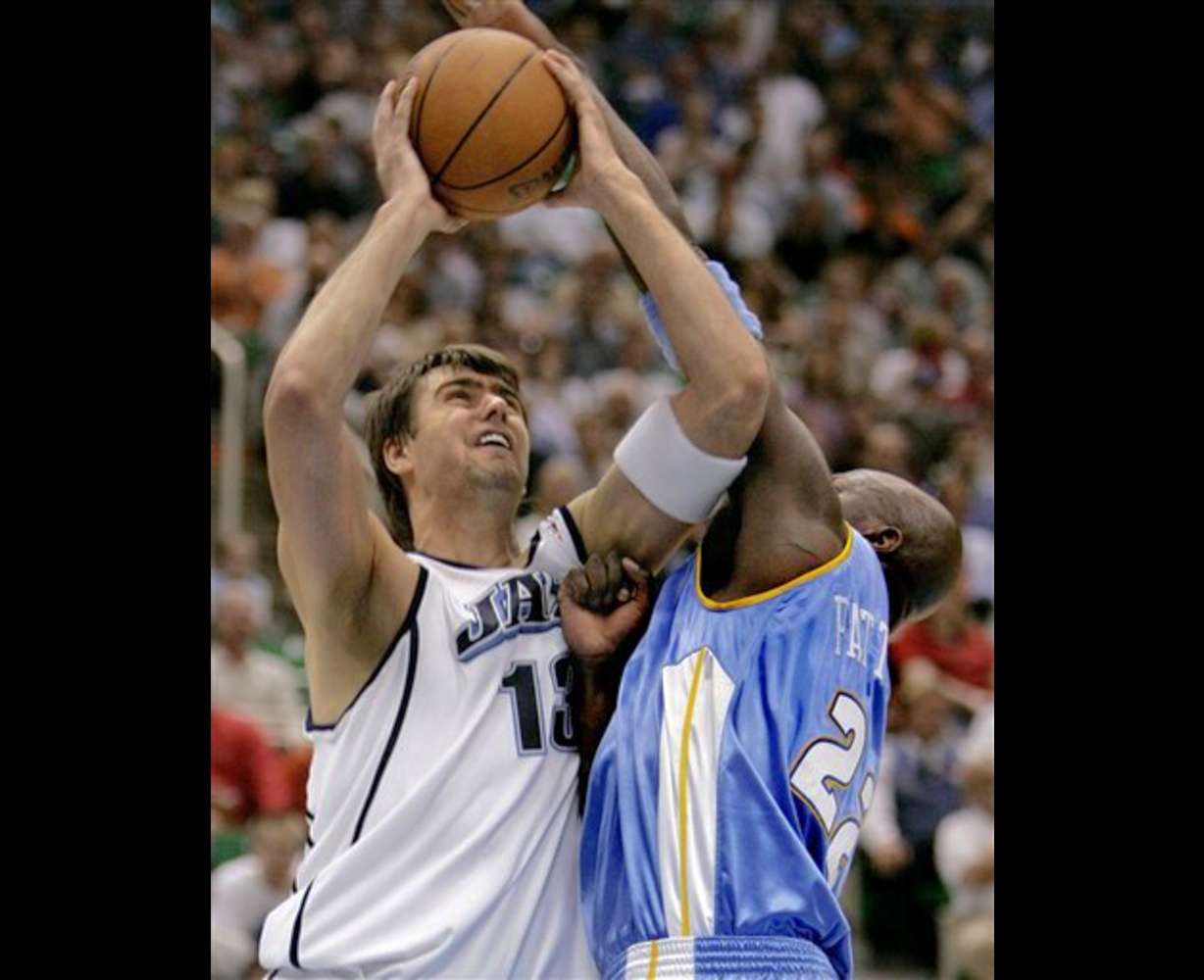 Utah Jazz forward Mehmet Okur (13), of Turkey, is fouled by Denver Nuggets forward Ruben Patterson (22) during the fourth quarter of an NBA basketball game Wednesday, April 12, 2006, in Salt Lake City. The Jazz won 104-83. (AP Photo/Douglas C. Pizac)