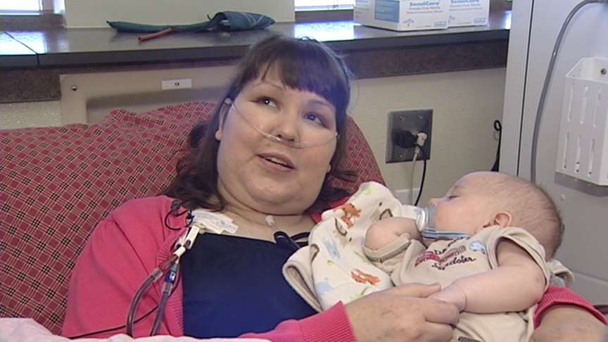 Jodi holds friend's baby while going through dialysis.