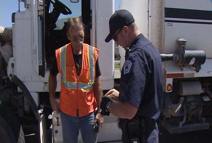 Layton police officer Ryan King talks with truck driver Ken Bair about his inspection
