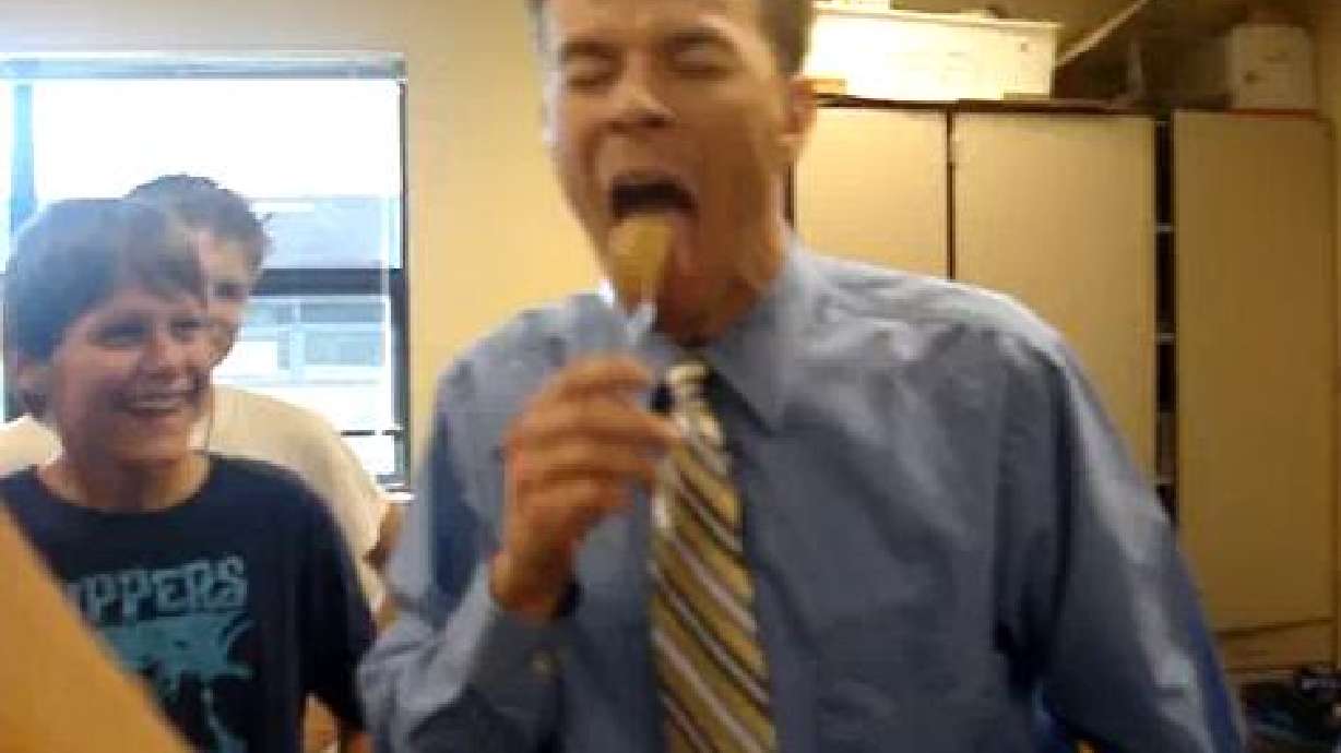 Teacher eats cricket after losing OU-BYU bet with students