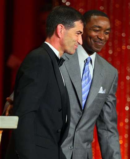 John Stockton is led from the podium by fellow Hall of Famer Isiah Thomas.