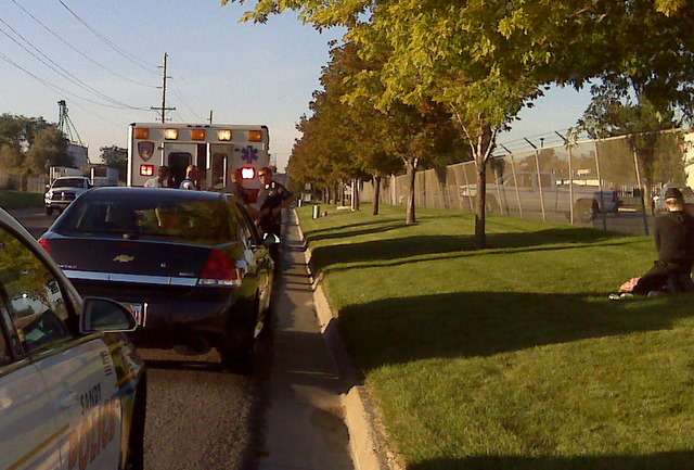 Carin Stoll (to the right in black) can be seen in this picture kneeling down tending to her infant after medical personnel took her 2-year-old.