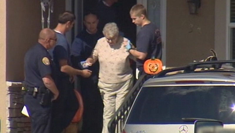 Investigators escort the victim's mother out of the house