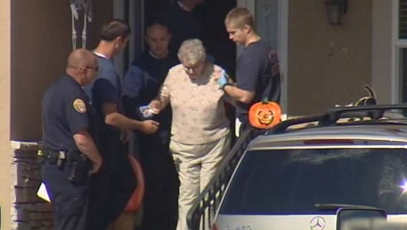 Investigators escort the victim's mother out of the house