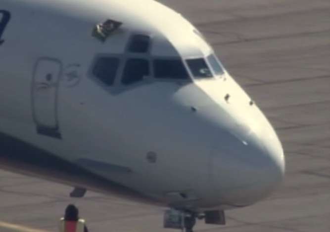 Damage to the plane can be seen above the windshield