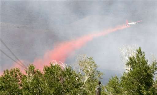 A slurry bomber drops retardant Sunday, July 1, 2007, over Whiterocks Canyon, near Neola, Utah. A wildfire that has scorched about 46 square miles in northeastern Utah and killed three people has prompted the evacuation of hundreds of people from nearby towns and forced authorities to close a national forest to the public. (AP Photo/The Salt Lake Tribune, Danny Chan La)