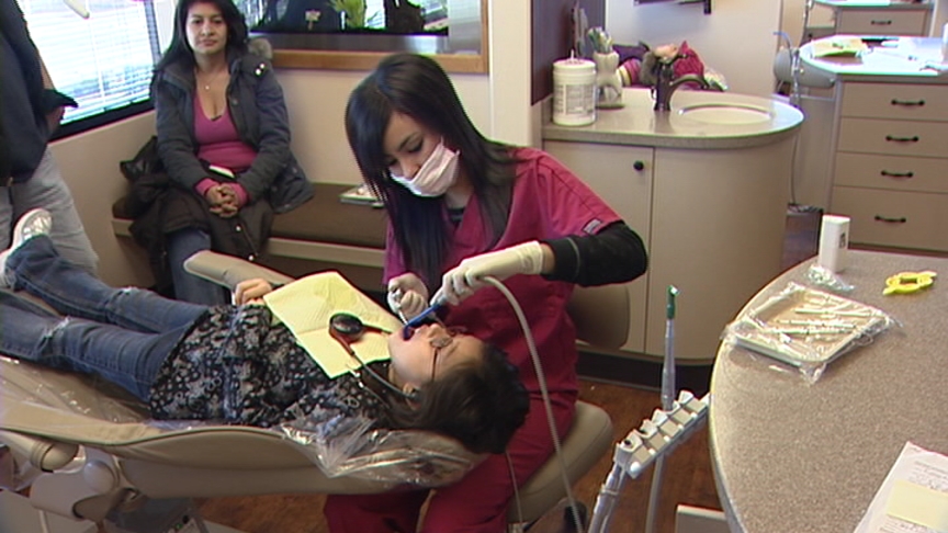 A dental hygienist works on a child during a free clinic at Pioneer Valley Dental Saturday.