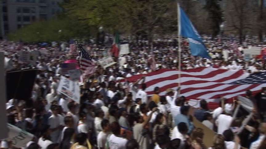 Protesters hold up signs and flags at a mass immigration reform rally in April 2006.