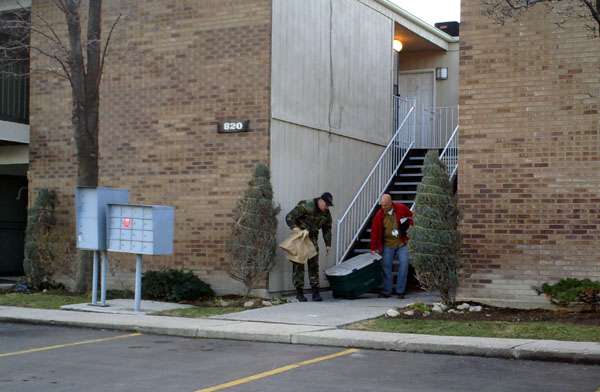 Police take evidence out of the condo where a man is accused of holding his girlfriend captive.
