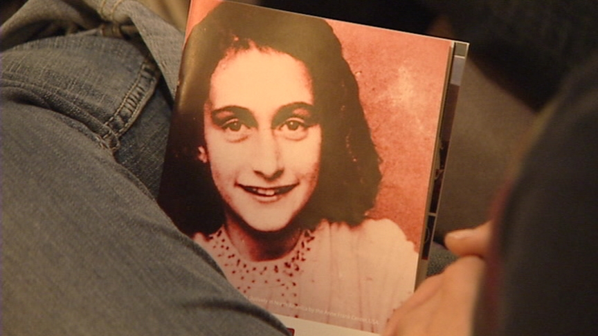 An attendee sits with a picture of Anne Frank. (Photo ©AFS/AFF, Amsterdam/Basel)